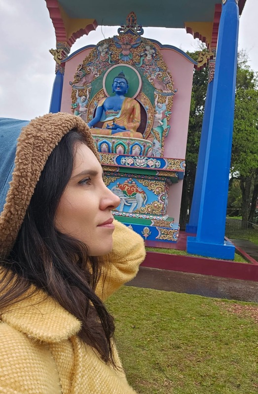 Retrato de Ana Paula Hasse ao ar livre, diante de uma construção colorida