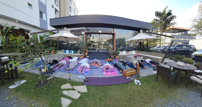Grupo em uma prática de yoga ao ar livre em frente a um café