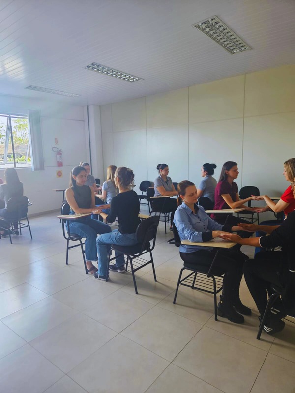 Atividade de yoga corporativo com participantes sentadas em cadeiras